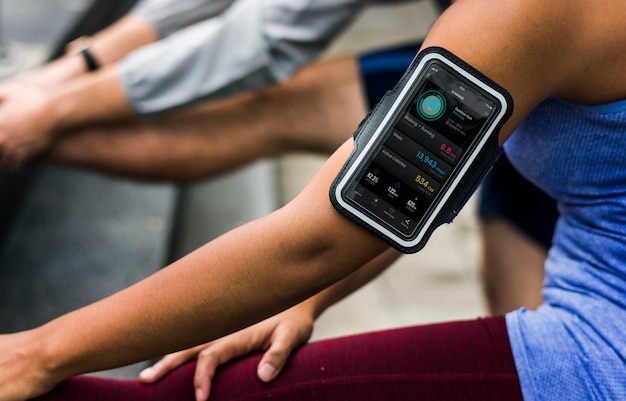 A close-up of a person's wrist wearing a smartwatch, displaying real-time heart rate and blood pressure data, integrated with an AI-driven health analytics platform on a smartphone screen.