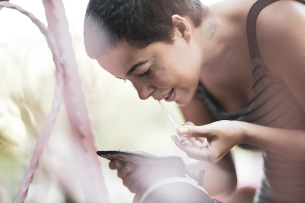 A person uses a smartphone to interact with a digital therapeutic app, displaying a personalized treatment plan. The background shows a doctor consulting with the patient, emphasizing the integration of DTx into traditional healthcare.