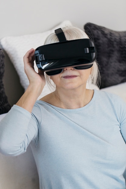 A close-up of a patient's face while wearing a VR headset, showing a look of concentration and engagement. The background is blurred, suggesting a clinical setting.