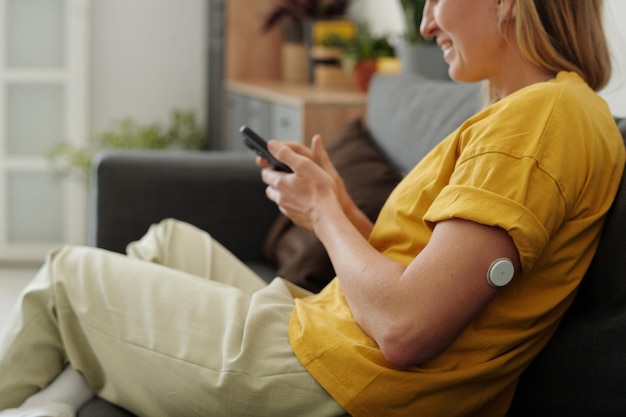 A person wearing a continuous glucose monitor (CGM) on their arm and checking their blood glucose levels on a smartphone. The image highlights the convenience and real-time data provided by CGMs.