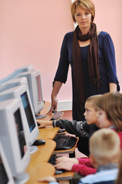 A teacher instructing students in a coding class, using modern computers and software. The image highlights the importance of integrating technology and coding skills into the curriculum to prepare students for future job roles.