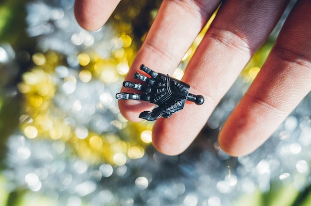 A clear close-up shows the hands of a student connecting sensors to a small robot's microcontroller. The background shows a laptop screen displaying code, indicating the integration of hardware and software in robotics education.