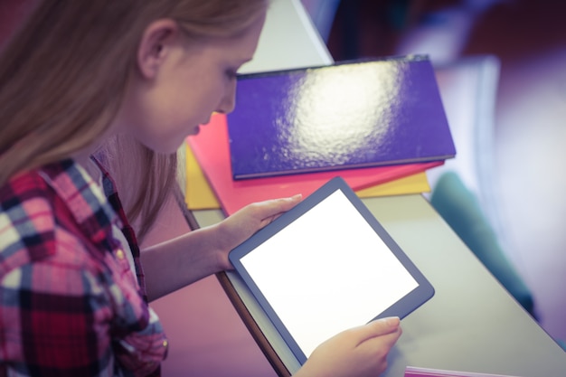 A close-up shot of a student's hands using a tablet with an educational math app. The app displays colorful diagrams and interactive problem-solving exercises. The student is focused and engaged.
