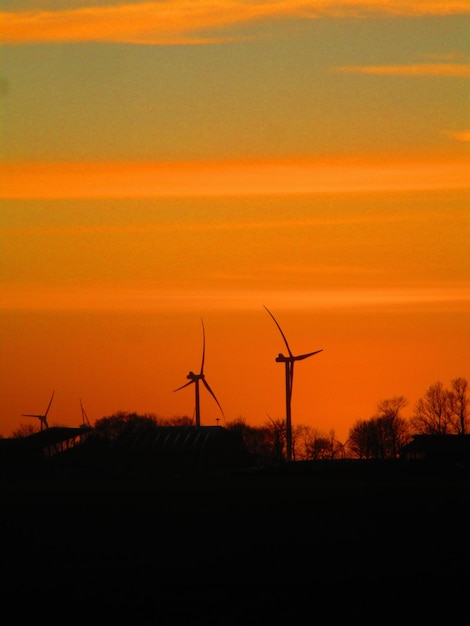 A wind farm at sunset, illustrating the potential of renewable energy and the need for continuous innovation and policy support.
