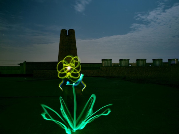 A futuristic image of genetically modified plants glowing in a field, symbolizing the potential of biotechnology in sustainable energy and environmental solutions.