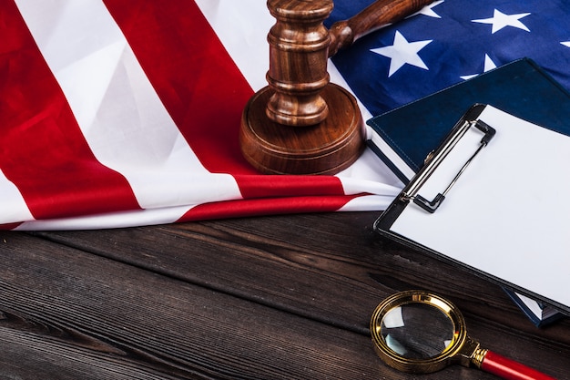 A gavel resting on a stack of legal documents, with the American flag in the background, symbolizing the legal considerations surrounding employee monitoring in the US.