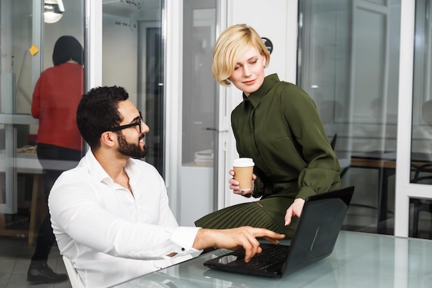 A manager having a one-on-one conversation with an employee in a comfortable office setting. The manager is actively listening and showing empathy. Plants and natural light create a calming atmosphere.